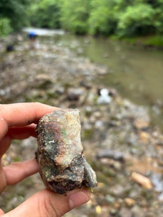 Bloc erratique de quartz minéralisé présentant des traces de malachite, un minéral secondaire de cuivre, identifié lors des travaux de terrain